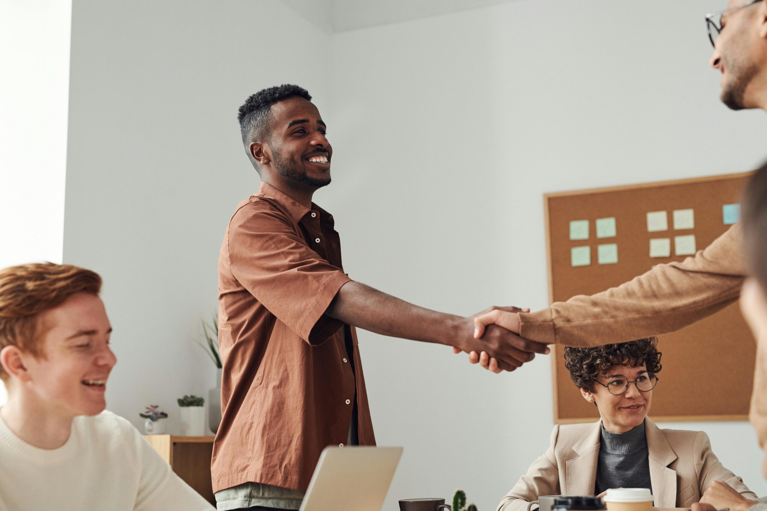 SERVICES Business team members shaking hands during a meeting, demonstrating cooperation and teamwork.